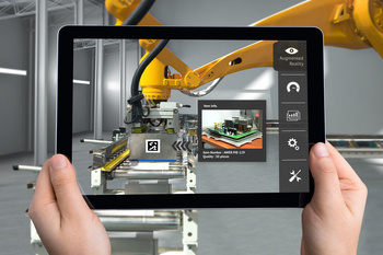Ein Tablet zeigt das Bild eines Industrieproduktionsroboters und die digitalen Daten aus dem System