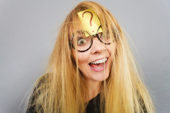 Funny looking woman with big glasses and a sticky note with ? on her forehead